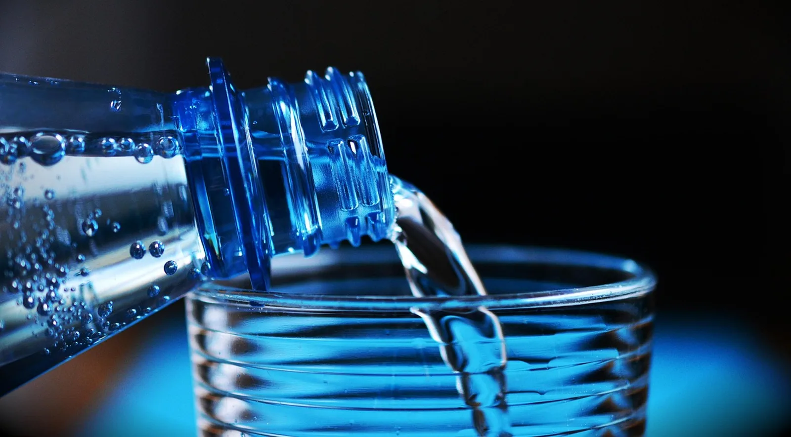 Klares Wasser wird ins Glas gegossen
